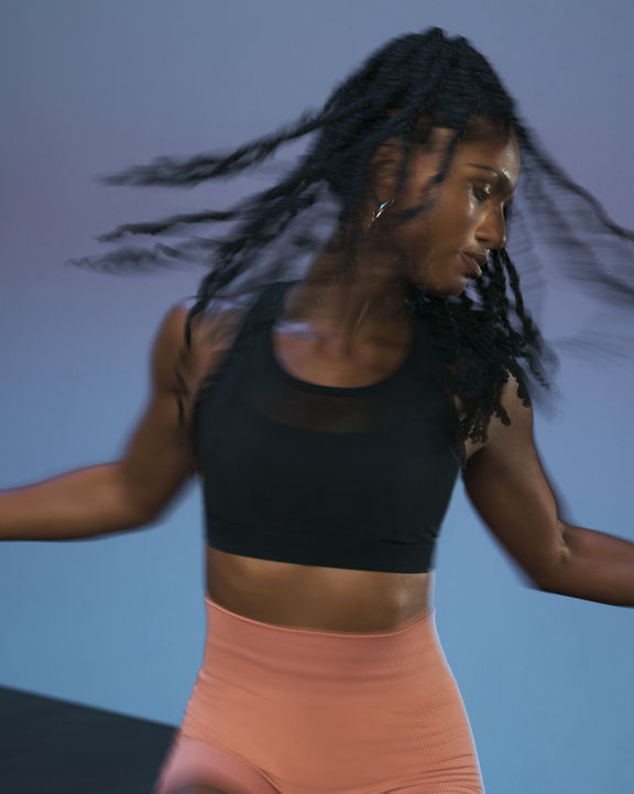 Close up of a Life Time member in motion during the sculpt portion of an AMP spin class