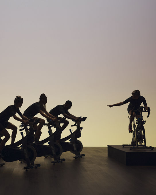 PWR spin class riding in silhouette with the instructor leading them