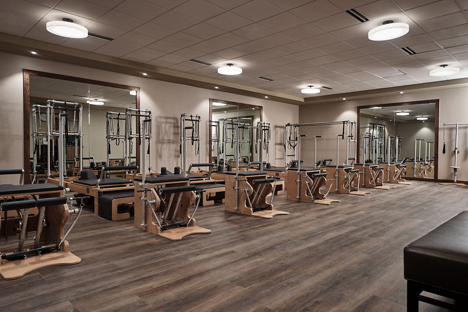 a row of pilates reformers in a pilates workout room             