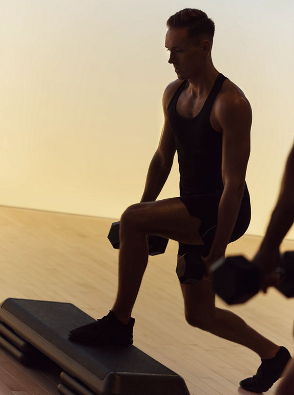 Xtreme cardio class member in split squat at Life Time